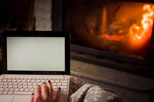 Girl Using Laptop By The Fireplace