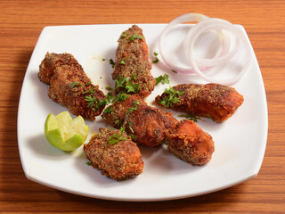 Deep fried spicy boneless fish fry served on a ceramic white plate, selective focus