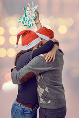 Middle-aged happy couple embracing each other holding a paper concept mistletoe and celebrating for christmas