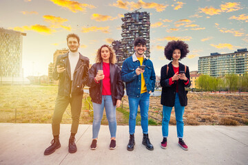 Group of multiethnic friends millennials using mobile phones looking at camera