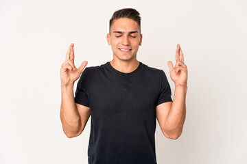 Naklejka premium Young caucasian handsome man isolated crossing fingers for having luck