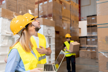Female warehouse manager consult delivery plans using database in laptop