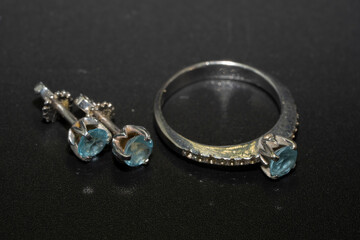 Ring and earrings in white gold with topaz on a black background