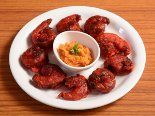 Delicious spicy prawns fry or Chemmeen roast or shrimp fry, served on a white ceramic plate over a rustic wooden background, selective focus