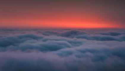 Fototapeta na wymiar Above the sea of clouds in the valley at morning sunrise