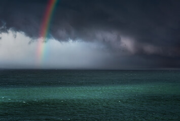 dramatic stormy clouds over the sea with a rainbow