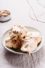 Homemade sweet meringue cookies on greige linen tablecloth. Delicious and light dessert