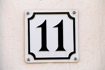 Hausnummernschild Nr. Elf auf heller Hauswand, Deutschland, Europa