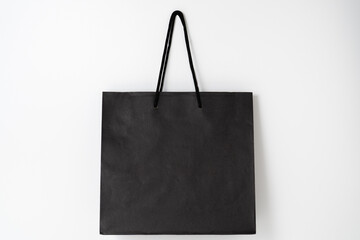 Mockup of black paper shopping bag on white background.