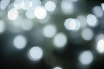 Abstract pattern of white bokeh lights on a dark background