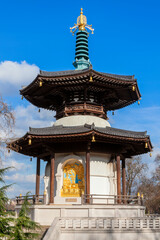 Fototapeta premium The Peace Pagoda in Battersea Park London England with gilded bronze gold Buddha statues which is a popular travel destination tourist attraction landmark of the city, stock photo image