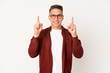 Young caucasian handsome man isolated indicates with both fore fingers up showing a blank space.