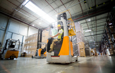 Forklift operator during work in large warehouse