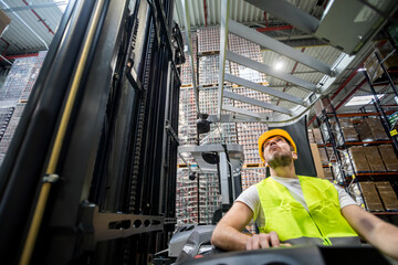 Forklift operator during work in large warehouse