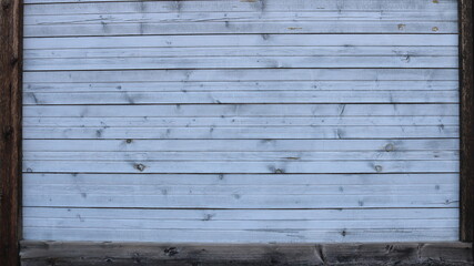 whitewashed wooden surface made of horizontal even planks with dotted knot patterns framed by brown contrasting edges as an empty design exterior or interior background