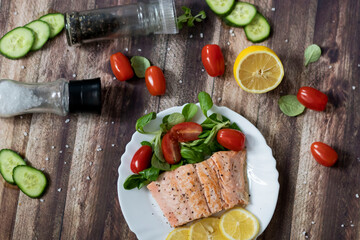 Salmon in a pan with lemon and other vegetables. Salmon on plates