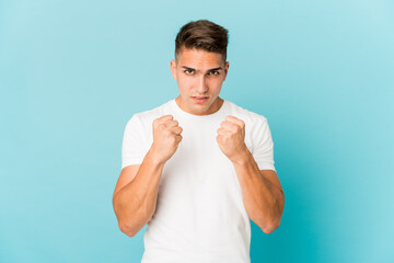 Young caucasian handsome man isolated showing fist to camera, aggressive facial expression.