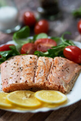Salmon in a pan with lemon and other vegetables. Salmon on plates