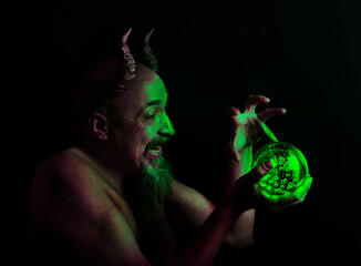 bearded middle-aged man with horns and a mystical luminous ball, magic ritual.
