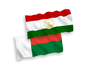 Obraz premium National vector fabric wave flags of Tajikistan and Madagascar isolated on white background. 1 to 2 proportion.