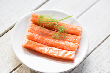Crab sticks on white plate and vegetable , Fresh crab sticks surimi ready to eat japanese food.