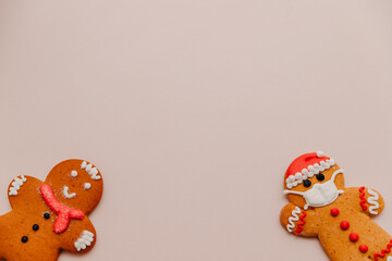 Obraz premium Two different gingerbread cookies: one with the image of a protective mask, and the other without it. The concept of conscious and safe celebration of Christmas and New Year