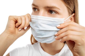 Young woman using medical protective mask to protect health and prevent virus, epidemic and infectious diseases, on white background