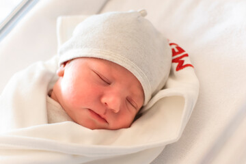 Portrait of cute and beautiful newborn baby in hospital after delivery. First days of life. Lifestyle