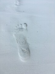 man's footprint on a white sand