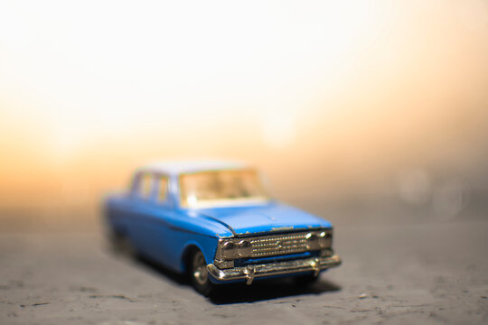 toy retro car in blue on a gray background. solar illumination
