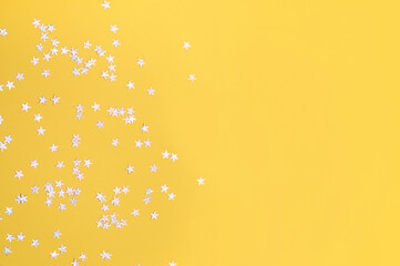 Obraz na płótnie Canvas Yellow background with stars, glitter spangles.