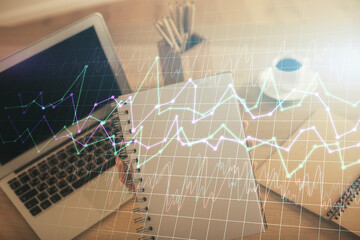 Double exposure of businesswoman hands typing on computer and forex chart hologram drawing....