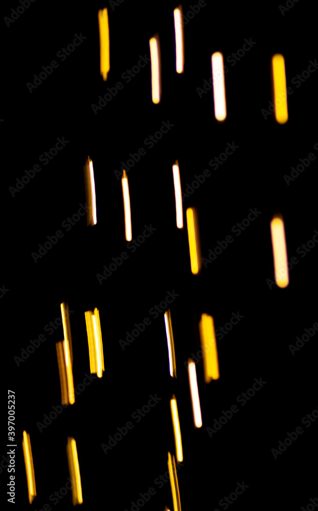 Poster bright yellow lights and sparks in defocus. bokeh effect on black background for overlay.