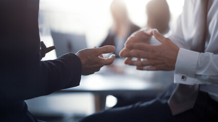Close up. Meeting of project leaders. Hands of a business people having a project discussion or business agreement together. Team work process. Blurred background. 16x9 size
