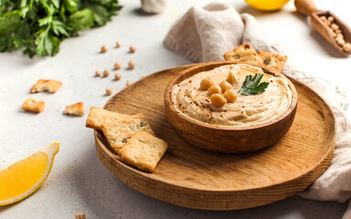 Hummus in a wooden plate with parsley and croutons. Dishes of chickpeas, a vegetarian dish.