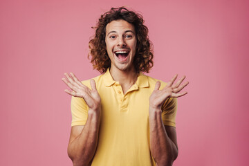 Excited handsome guy pointing expressing surprise on camera