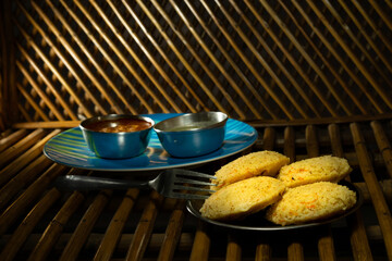 Homemade tasty rava idly in a plate along with chutney and curry