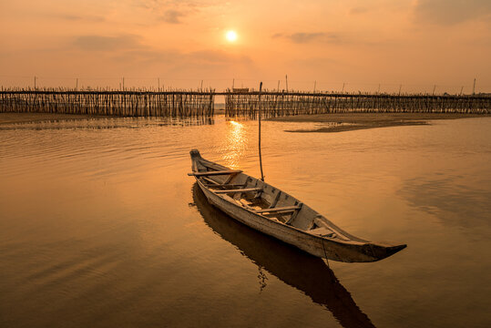 Wooden boat at sunset, Ko Paen Bamboo bridge, Kompong Cham, Cambodia. This temporary bamboo bridge is reconstructed every year to span a contributory to the Mekong from main city to an island.