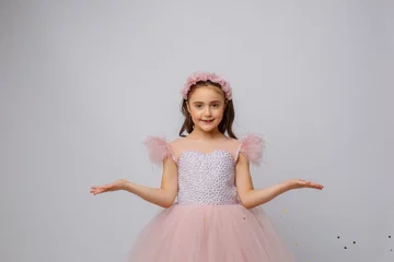Fotobehang little girl in a beautiful dress prinses on a white background © Olesya Pogosskaya