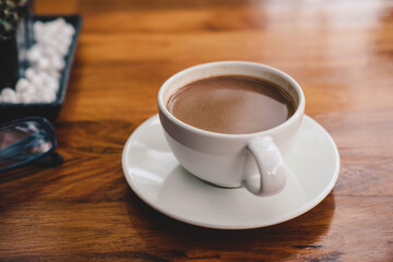 .A cup of coffee on a wooden table in a coffee shop