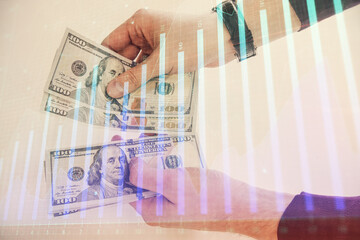 Multi exposure of financial graph drawing hologram and USA dollars bills and man hands. Analysis concept.