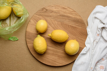 ripe yellow lemons on a brown wooden board, ingredient for lemonade