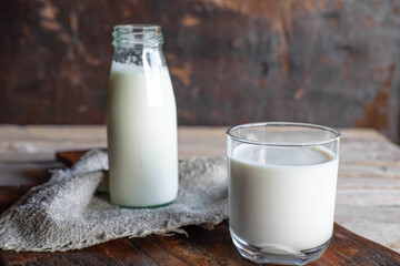.Bottles and milk glasses on a wooden table