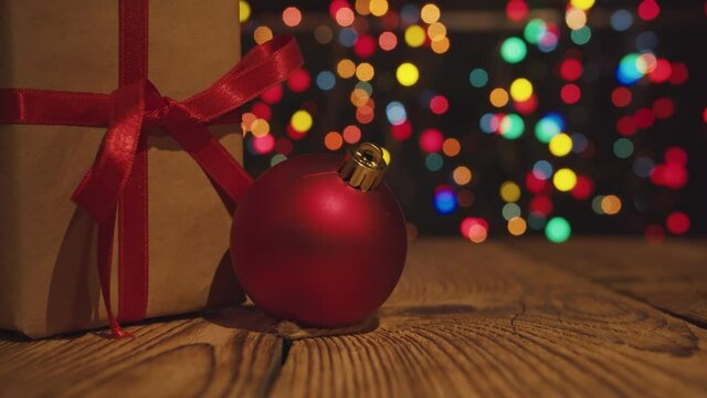 Close-up of the christmas gift boxe with red ribbon on table with bokeh lights.