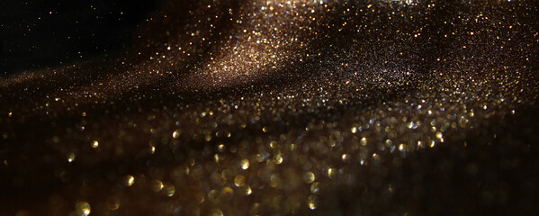 background of abstract gold and black glitter lights. defocused