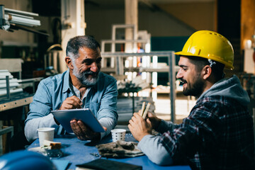 blue collar workers talking on lunch break at warehouse
