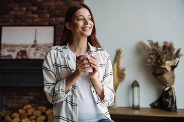 Beautiful happy nice woman smiling and drinking coffee