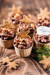 Chocolate cupcakes with star shaped cookies on a wooden background. Christmas mood. Sweets for any occasion. Vertical orientation