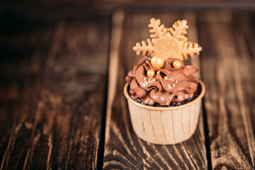 Chocolate cupcakes with star shaped cookies on a wooden background. Christmas mood. Sweets for any occasion