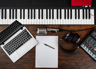 Music studio equipment and white paper with pen. Songwriting concept.